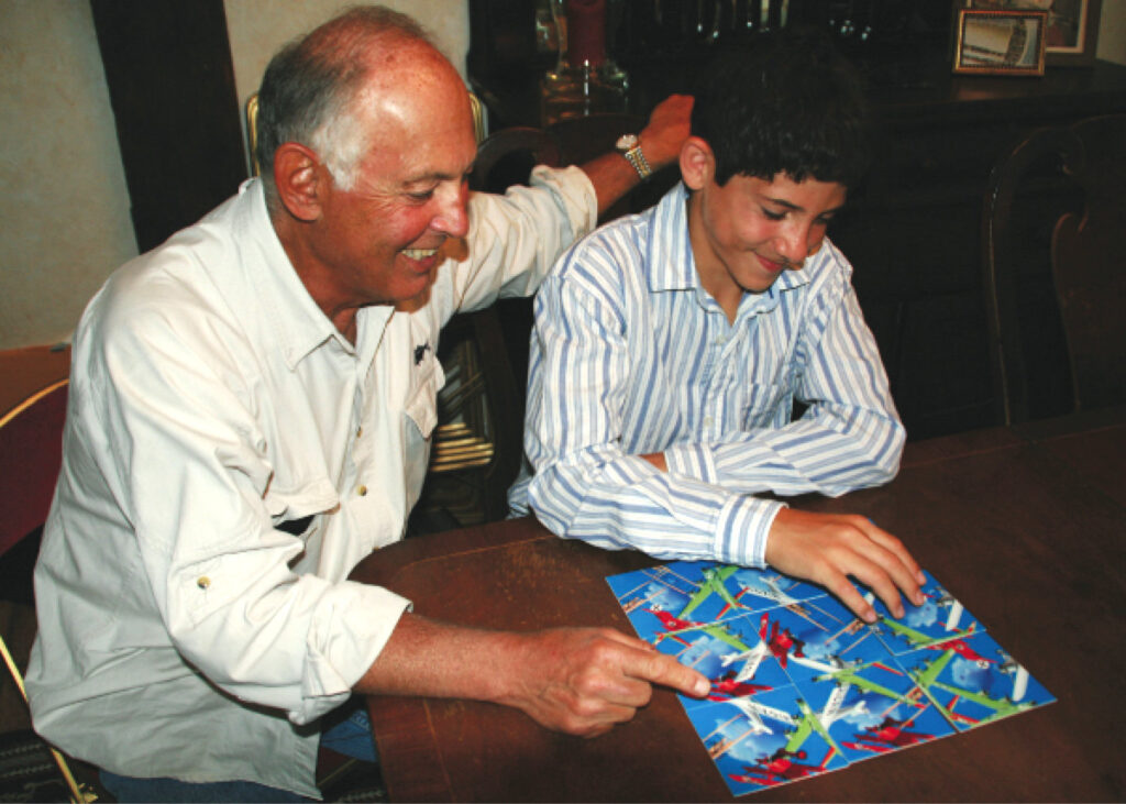 A grandfather and grandson bonding over a Scramble Squares® puzzle.